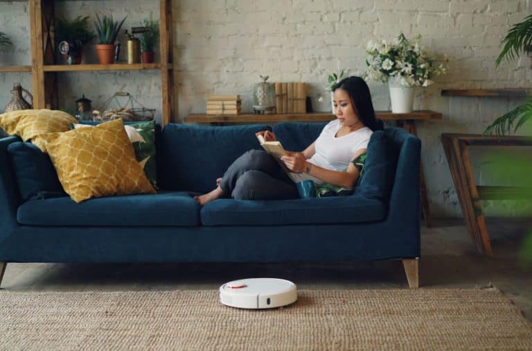 woman on couch with Roomba